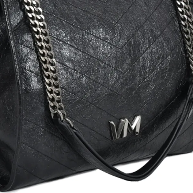 Close-up da bolsa Via Marte preta com acabamento craquelê e alça de corrente